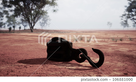 A rusty metal hook on a vibrant red dirt road A rusty metal hook on a vibrant red dirt road 106881000