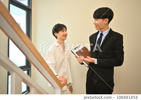 Male realtor wearing suit showing new house to smiling buyer. Real estate mortgage and property investment concept 106881858