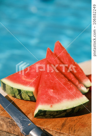 sliced watermelon is lying by the pool 106882249