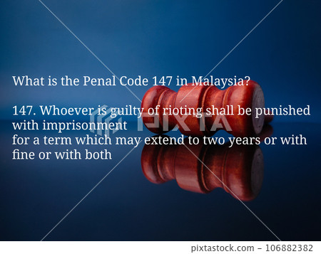 Text What is the Panel code 147 in Malaysia on a wooden gavel background. 147. Whoever is guilty of rioting shall be punished with imprisonment for a term which may extend to two years or with fine or 106882382