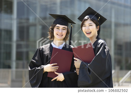 Two female students wearing academic gowns Graduation ceremony image Two female students wearing academic gowns Graduation ceremony image 106882502