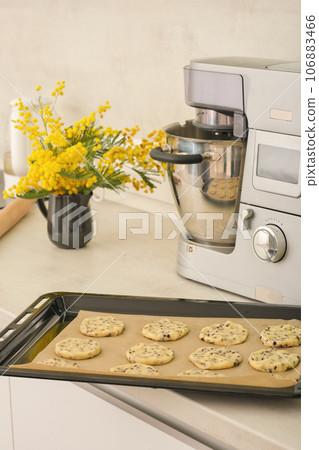 raw chocolate chip cookies on baking sheet ready to bake in oven. kitchen stand mixer background. vertical shot. 106883466