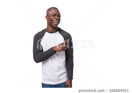 young handsome american man dressed in a long-sleeved sweater announces the news using gestures 106884051