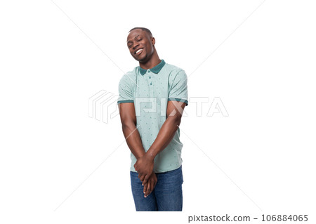 young slender American man dressed in a T-shirt and jeans smiling shyly 106884065