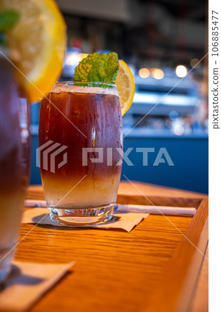 Cold layered coffee drink with lemon slice and mint leaf 106885477