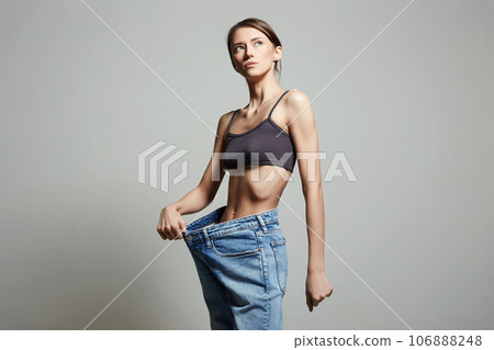 slimming Young woman in jeans. low waist. Beautiful Thin body Girl slimming Young woman in jeans. low waist. Beautiful Thin body Girl 106888248