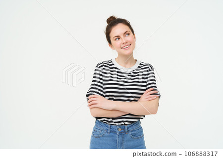 Portrait of woman smiling, cross arms on chest, looks aside with thoughtful face, thinking, making choice, imaging something, standing over white background 106888317
