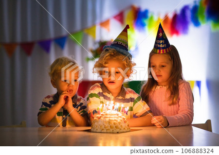 Kids birthday party. Children blow cake candles. 106888324