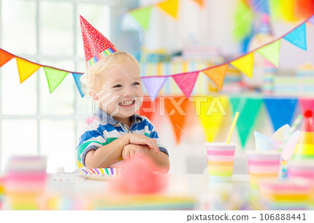 Kids birthday party. Child blowing out cake candle Kids birthday party. Child blowing out cake candle 106888441