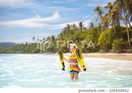 Child with swim fins snorkeling on tropical beach. Child with swim fins snorkeling on tropical beach. 106888602