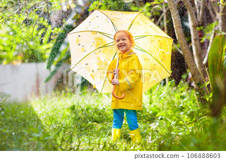 Child playing in the rain. Kid with umbrella. Child playing in the rain. Kid with umbrella. 106888603