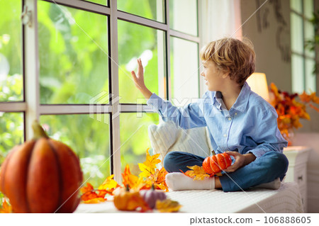 Child at window in autumn. Kids at home in fall. Child at window in autumn. Kids at home in fall. 106888605