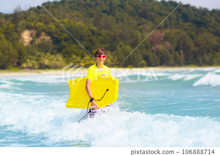 Surfer on tropical beach. Boy surfing. 106888714