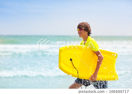 Surfer on tropical beach. Boy surfing. Surfer on tropical beach. Boy surfing. 106888717