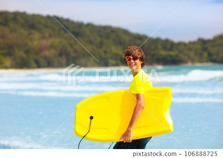 Surfer on tropical beach. Boy surfing. 106888725