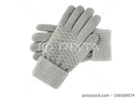 Women's knitted gloves lie one on top of the other on a white background. Women's knitted gloves lie one on top of the other on a white background. 106889074