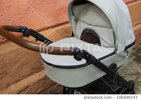 an empty baby stroller near a brick wall. An increase in the birth rate. Social problem 106890143