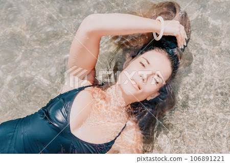Woman summer travel sea. Happy tourist enjoy taking picture outdoors for memories. Woman traveler posing on the beach at sea surrounded by volcanic mountains, sharing travel adventure journey Woman summer travel sea. Happy tourist enjoy taking picture outdoors for memories. Woman traveler posing on the beach at sea surrounded by volcanic mountains, sharing travel adventure journey 106891221