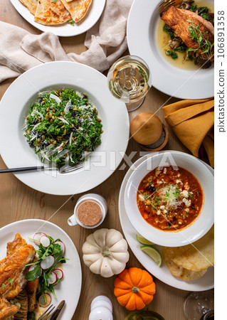 Fall dinner table with soup, salad and main dishes Fall dinner table with soup, salad and main dishes 106891358