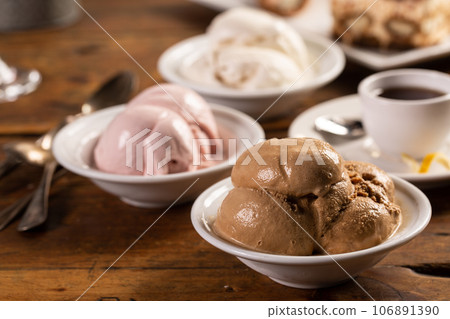 Variety of italian gelato served in bowls on a wooden table Variety of italian gelato served in bowls on a wooden table 106891390