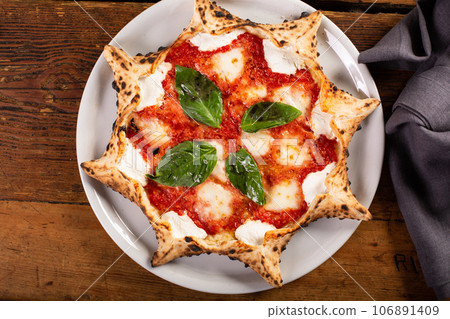 Freshly baked carnival pizza margarita with fresh basil 106891409