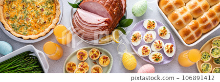 Easter brunch table with ham, quiche, hot cross buns Easter brunch table with ham, quiche, hot cross buns 106891412