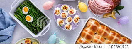 Easter brunch table with ham, quiche, hot cross buns 106891413