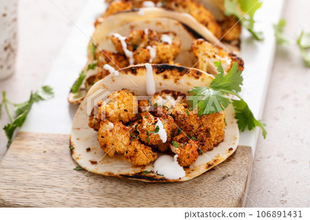 Spicy cauliflower tacos with cilantro and mexican crema Spicy cauliflower tacos with cilantro and mexican crema 106891431