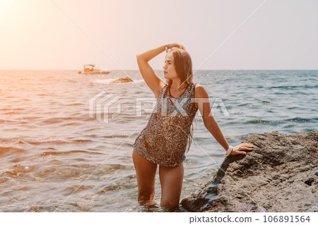 Woman summer travel sea. Happy tourist enjoy taking picture outdoors for memories. Woman traveler posing on the beach at sea surrounded by volcanic mountains, sharing travel adventure journey Woman summer travel sea. Happy tourist enjoy taking picture outdoors for memories. Woman traveler posing on the beach at sea surrounded by volcanic mountains, sharing travel adventure journey 106891564