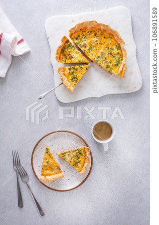 Homemade quiche with ham and cheese cut on the table 106891589