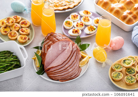 Easter brunch table with ham, quiche, hot cross buns Easter brunch table with ham, quiche, hot cross buns 106891641