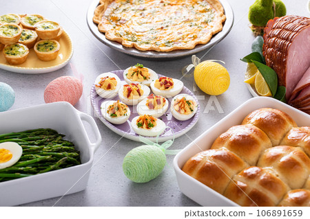 Easter brunch table with ham, quiche, hot cross buns 106891659