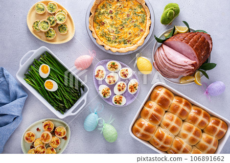 Easter brunch table with ham, quiche, hot cross buns Easter brunch table with ham, quiche, hot cross buns 106891662
