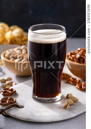 Dark stout beer in a tall glass on the table Dark stout beer in a tall glass on the table 106891696