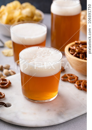 Traditional lager beer in variety of glasses with snacks on the table Traditional lager beer in variety of glasses with snacks on the table 106891750
