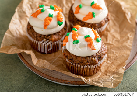 Carrot cupcakes with cream cheese frosting decorated with tiny carrots Carrot cupcakes with cream cheese frosting decorated with tiny carrots 106891767