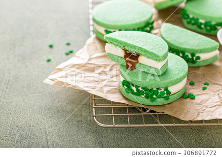 Green sandwich cookies with salted caramel and shamrock sprinkles Green sandwich cookies with salted caramel and shamrock sprinkles 106891772