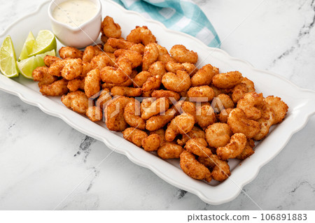 Coconut shrimp with ranch dip and lime wedges 106891883
