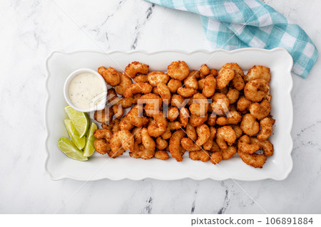 Coconut shrimp with ranch dip and lime wedges 106891884