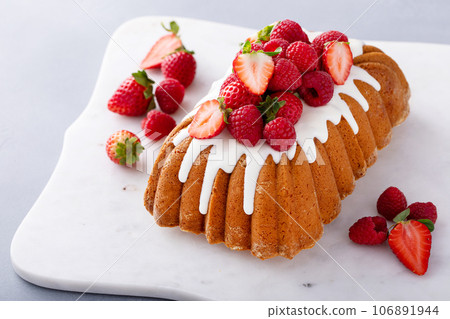 Traditional pound cake topped with glaze and fresh berries Traditional pound cake topped with glaze and fresh berries 106891944