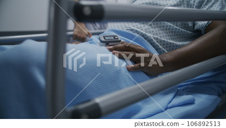Injured man lies in neck brace and with pulse oximeter on finger Injured man lies in neck brace and with pulse oximeter on finger 106892513