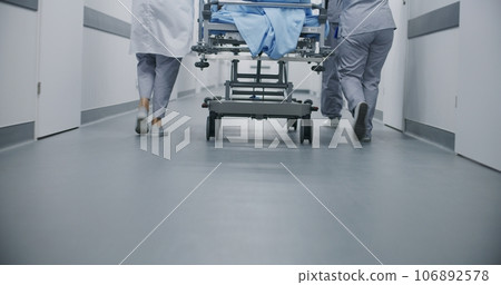 Doctors and paramedics move gurney with patient 106892578