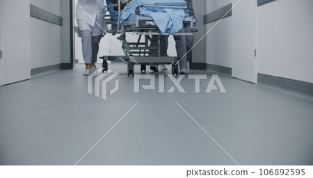 Doctors and paramedics move gurney with patient Doctors and paramedics move gurney with patient 106892595