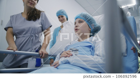 Girl lies on gurney and shows pulse oximeter to medic Girl lies on gurney and shows pulse oximeter to medic 106892596