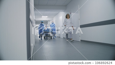 Doctors push stretcher with injured patient 106892624
