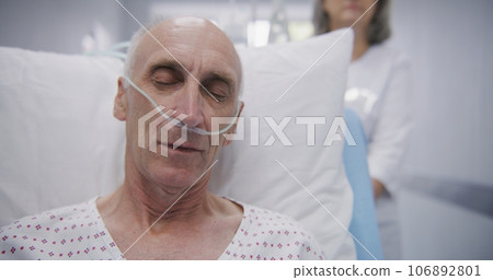 Senior patient sits on gurney with drip, breathing tube and sleeps Senior patient sits on gurney with drip, breathing tube and sleeps 106892801