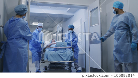 Medical personnel push gurney to operating room 106892814