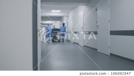 Doctors push stretcher with man to surgery room Doctors push stretcher with man to surgery room 106892847