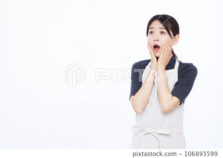 一位 30 多歲的家庭主婦在白色背景前看起來很驚訝 一位 30 多歲的家庭主婦在白色背景前看起來很驚訝 106893599