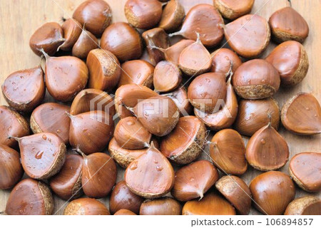 many chestnuts on a wooden table many chestnuts on a wooden table 106894857